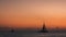 Enjoying the sunset while sailboats pass by the sunset horizon