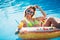 Enjoying suntan Woman in bikini on the inflatable mattress in the swimming pool