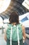 Enjoying travel. Young woman waiting on the station platform with backpack on background electric train. Tourist plan route