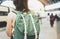 Enjoying travel. Young woman waiting on the station platform with backpack on background electric train. Tourist plan route