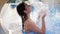 Enjoyment of Young Woman under Refreshing waterfall in swimming pool Outdoors on Summer rest