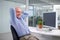 He enjoys his job way too much to retire. Portrait of a relaxed mature businessman sitting at his office desk.