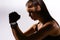 Enlarged profile dark photo of fitness woman exercising, looking down, on gray background. Sweaty caucasian brunette