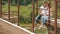 Enloved sensual couple kissing while sitting on bridge at summertime