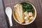 Enoki Miso Soup with tofu cheese and seaweed close-up in a bowl. Horizontal top view