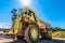 Enormous dumper truck under sun.