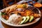 enormous plate of food, overflowing with rice and beans, chicken, and fish