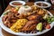 enormous plate of food, overflowing with rice and beans, chicken, and fish