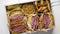 Enormous sandwiches with pastrami beef in wooden box. Served with baked potatoes, pickles
