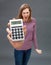 Enraged young woman screaming against financial economy on oversized calculator