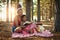 Ensuring her little one stays a keen reader. a mother and her little daughter reading a book together in the woods.