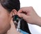 ENT physician checking patient\'s ear using otoscope with an inst