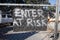 Enter at risk sign on gate hand made from wood