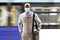 Enterprising black man wearing a face mask walking near a moving subway train