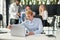 Enterprising caucasian office manager sitting at his workplace at office and studying report`s datas in the meeting room