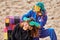 Entertainer in blue overalls and beast mask playing with hair of young woman at costume festival