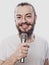 The entertainer. Young talking man holding microphone, Isolated on white background.