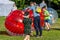 Entertainment of zorbing in the park. Children rolling downhill inside an orb sphere. Enjoy of childhood.