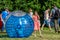 Entertainment of zorbing in the park. Children rolling downhill inside an orb sphere. Enjoy of childhood.