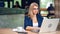 Enthusiastic adorable business female in trendy glasses working using laptop at cafe medium shot