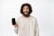 Enthusiastic bearded guy showing smartphone screen and looking amazed, recommending app or store in internet, white