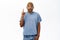 Enthusiastic Black guy points finger up, looks excited, has an idea, stands over white background