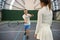 Enthusiastic man trainer teaching woman to serve ball tennis