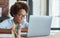 Enthusiastic mixed race teen schoolgirl listening to her teacher while using laptop during online video lesson, studying