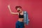 Enthusiastic sporty girl in sunglasses dancing on claret background. Studio shot of pleased black-haired woman in tank