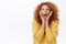 Enthusiastic, surprised and excited smiling silly redhead woman with curly hair, yellow sweater, sighing and stare with
