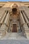 Entrance of al Rifai Mosque with closed decorated wooden door, ornate columns, ornate recessed stone wall and stairs, Cairo, Egypt