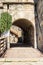 Entrance Bridge of the museum of the castello di san giusto with a tunnel and a drawbridge. In the background is a statue