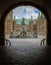 Entrance through a dark gate under an arch to Frederiksborg cast