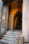 Entrance door of a decayed building with classic columns, stairs and arcade