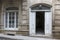 Entrance doorway in an ancient stone wall with stairs leading up.      the old metal wrought-iron door is locked with a padlock. C