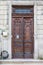 Entrance doorway in an ancient stone wall with stairs leading up.      the old metal wrought-iron door is locked with a padlock. C