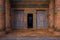 Entrance doorway to ancient Egyptian tomb or temple with blue and gold painted decorative columns and walls. 3D rendering
