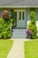 Entrance of family house with doorsteps and concrete pathway in front.