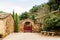 Entrance at Fontfroide Abbey monastery in France. Red gate and stone bench