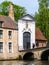 Entrance gate to Begijnhof, Beguinage, and bridge over canal in Bruges, Belgium