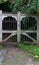 Entrance of a graveyard with a closed wooden and wrought-iron ga