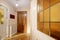 Entrance hall of a house with an armored access door, white wooden doors with leaded glass, oak slat parquet and mesh radiator