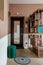 Entrance hall in a modern apartment made in retro style with bookshelves and a green pouf and a sofa