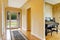 Entrance hallway with glass door, hardwood floor and rug.