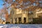 Entrance of landscaped stucco two story house with snow on the ground in upscale neighborhood