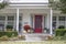 Entrance and porch to pretty house with Autumn and Halloween decorations and fall leaves blowing in the wind - curb appeal