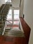 Entrance with red tiles, gray walls, stairs with railings