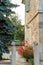 Entrance to a beautiful stone house adorned with red flowers and trees, on a late spring day