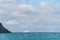 Entrance to Drygalski Fjord, South Georgia, glacier melt blue water, cloudy sky, rocky shoreline, and iceberg in background