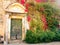 Entrance to a house with portico and wooden door overgrown with ivy, Ravello, Italy